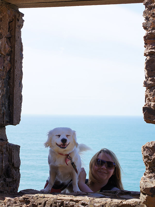 Looking through the window of an old engine house at the sea