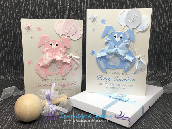 Picture of two greeting cards in pink and blue with rabbits with curly whiskers and holding balloons