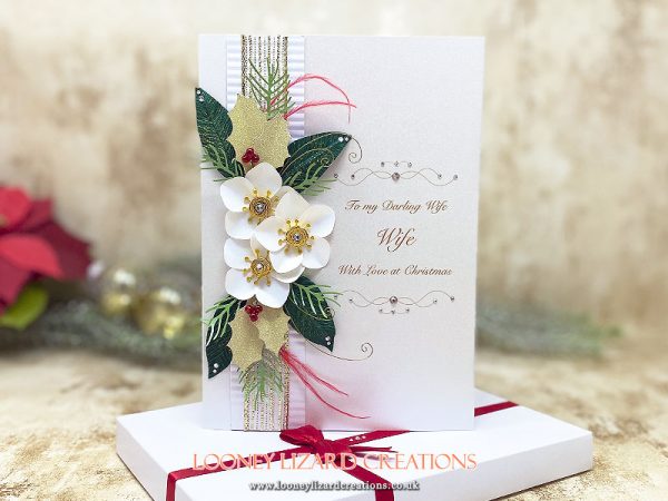 a wintery christmas card featuring winter flowers and foliage made from papers