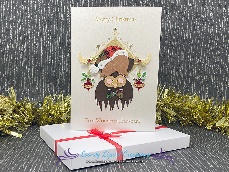 picture of a card featuring a highland cow with festively decorated horns
