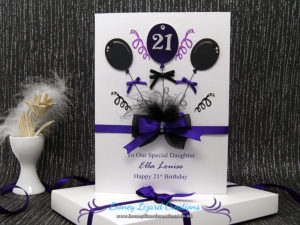 card featuring a trio of balloons with streamers and bow