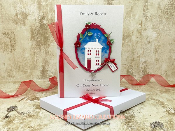 card featuring a little white house with red door and curtains.